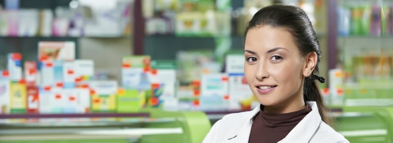 Pharmacist in front of counter displays.